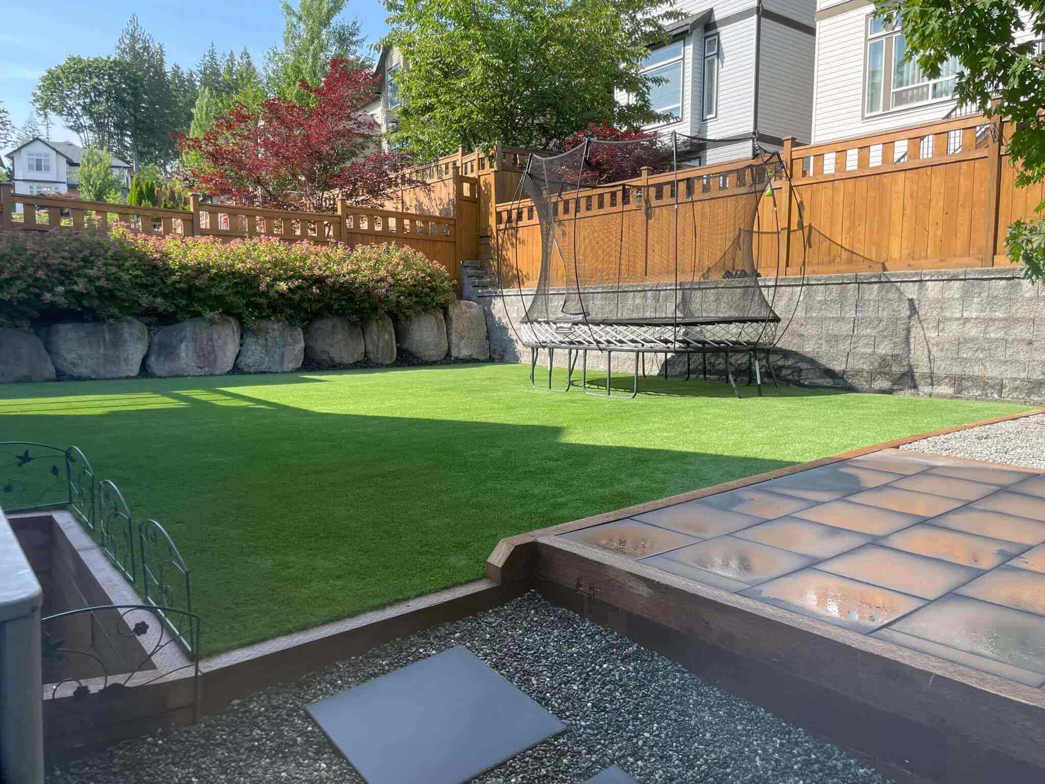 a pristine backyard artificial turf install with brand new fencing surrounding