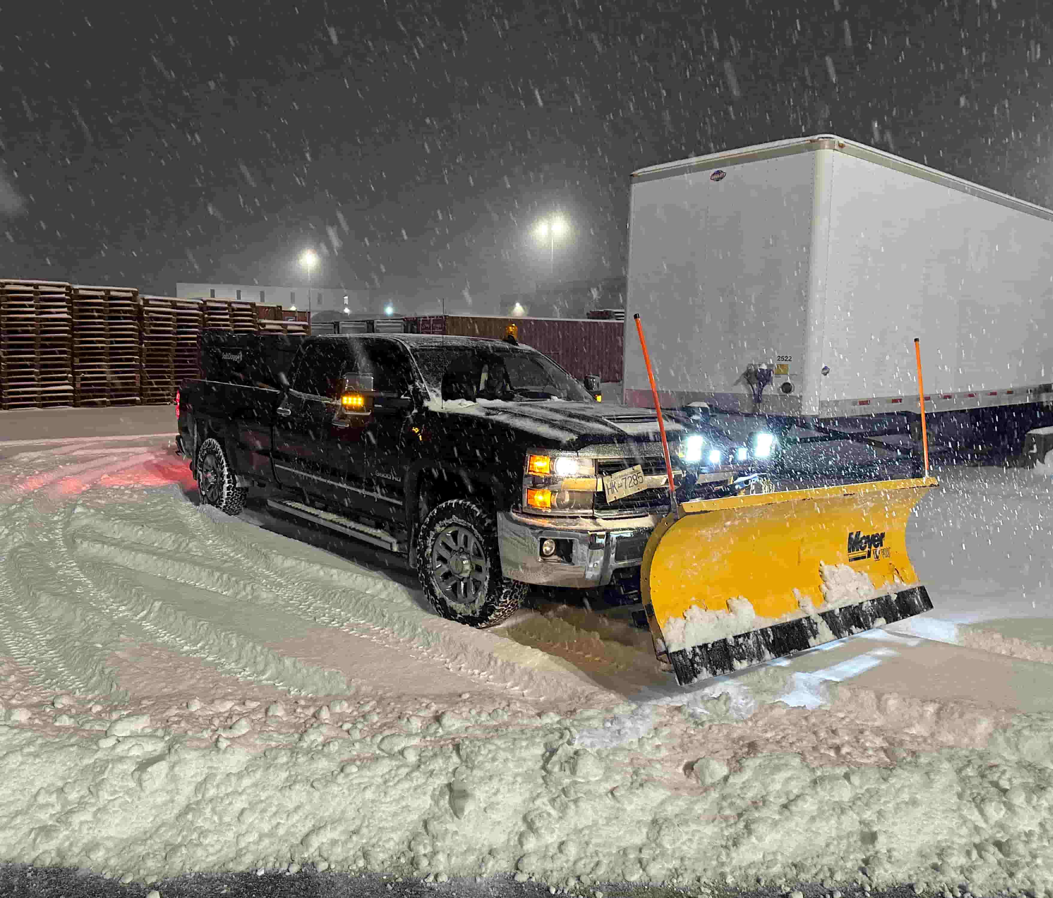 a Turf Bros truck fitted with a snow plow parked in a snow covered parking lot