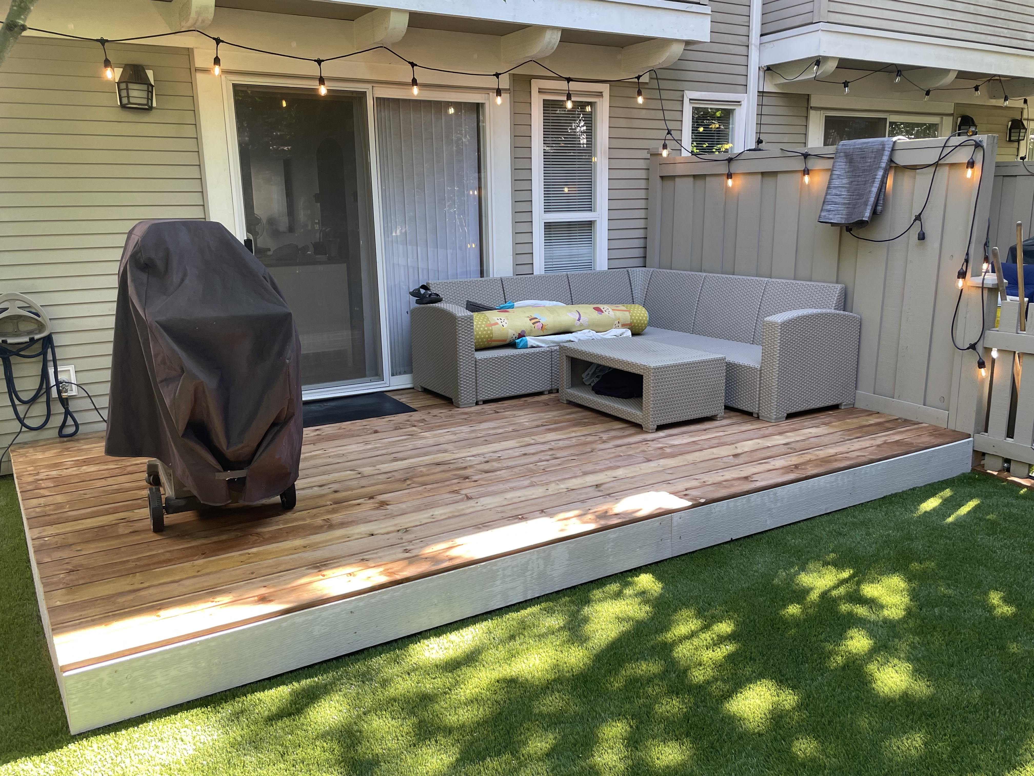 a well designed backyard patio accompanying artificial turf