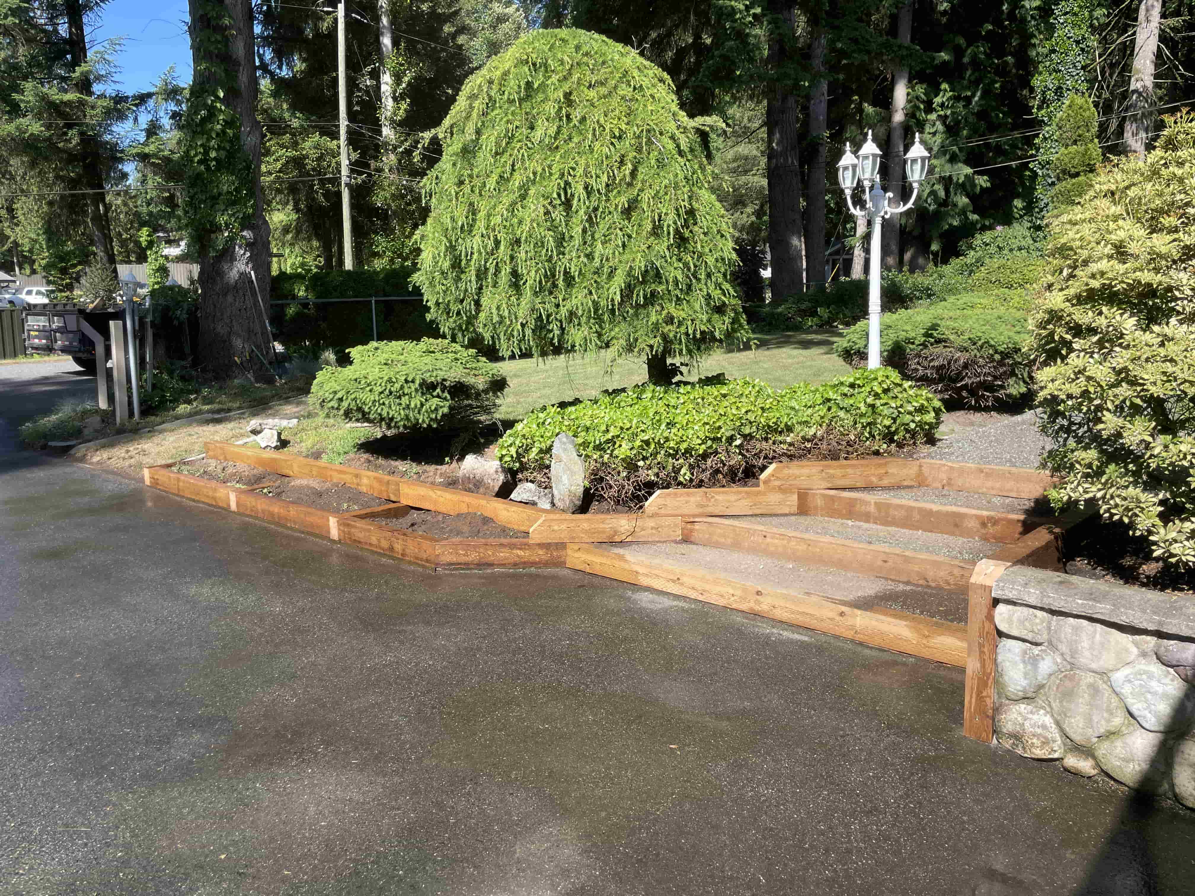 a driveway and front entry with brand new landscaping ties installed